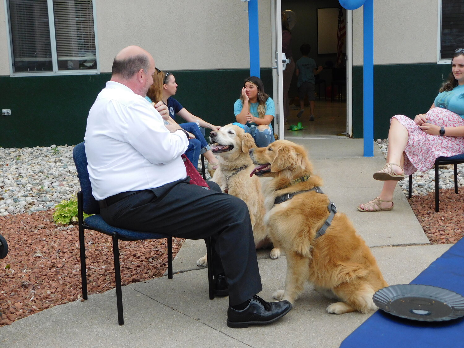 Tom Evans, chief assistant prosecuting attorney, shares a moment discussing the merits of “sharing one more hot dog” with his golden retriever, Joe, and the dog of the hour, Trigger.